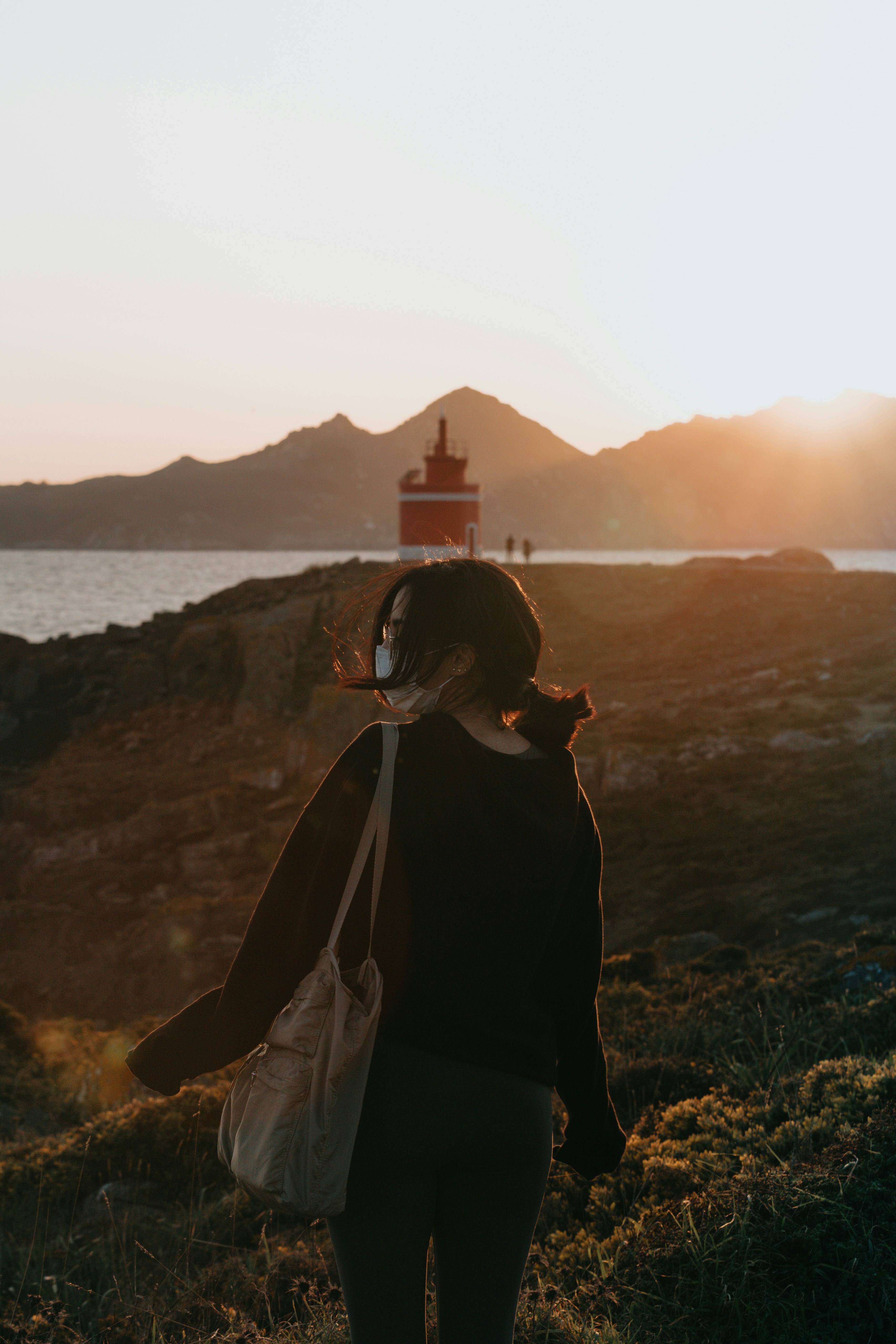 woman in black dress standing on brown rock formation during daytime